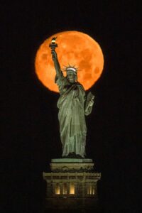 Moon rise behind the Statue of Liberty in New York