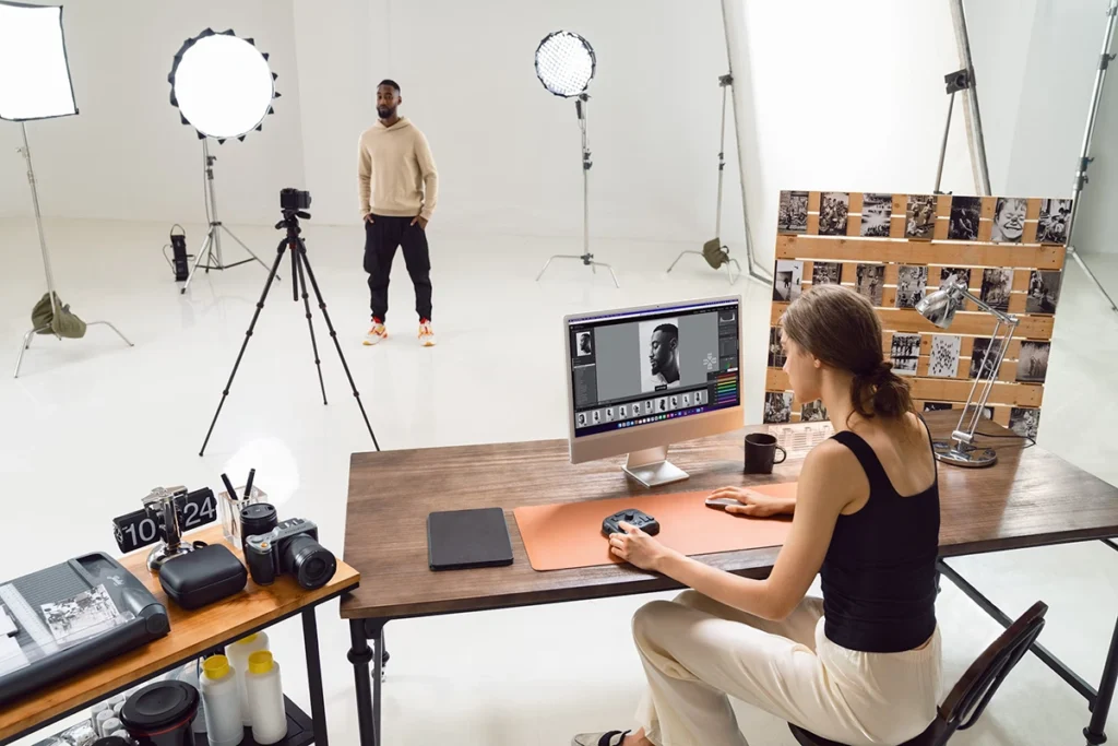 Photographer editing a portrait on her computer in her photo studio
